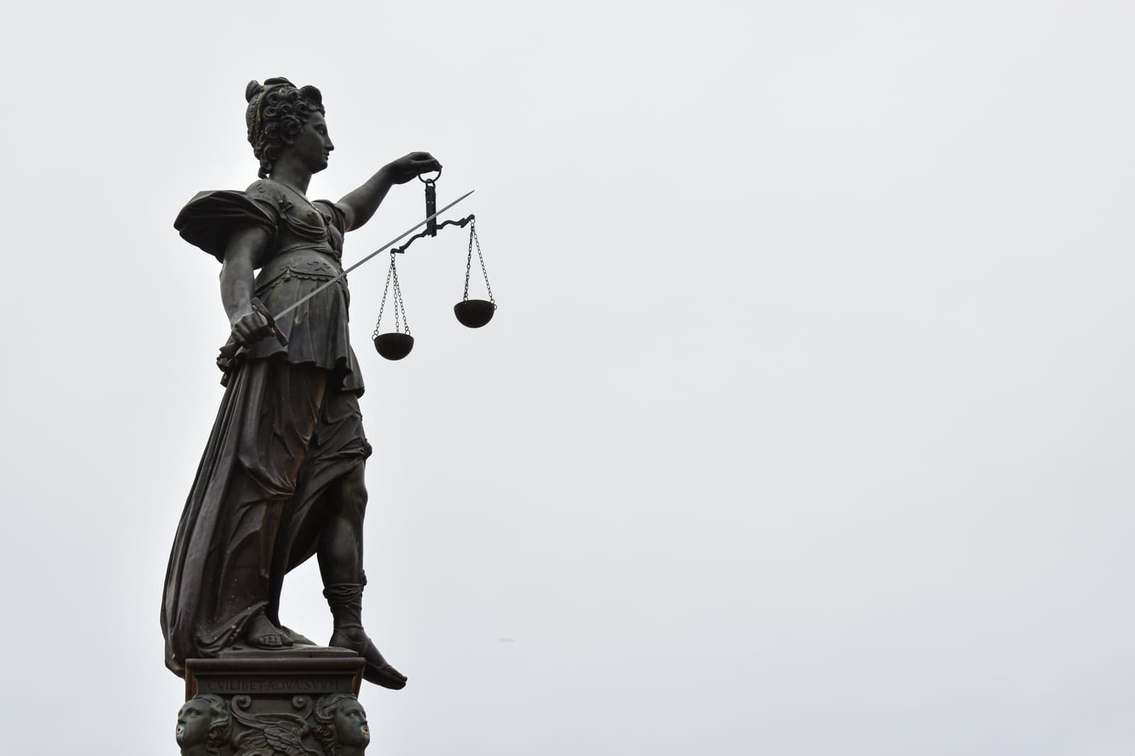 Picture of a statue of Themis, goddess of Justice, holding scales and a sword
